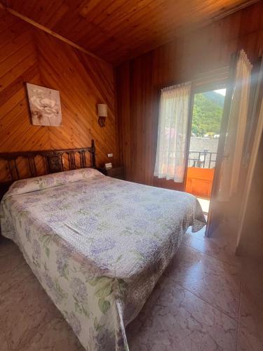 a bedroom with a bed and a large window at Pensión Montarto in Arties