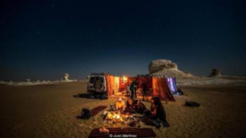 a group of people on the beach at night at White Desert in Bawiti
