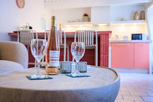 圣保罗-德旺斯Apt Cezanne的桌子上放有一瓶葡萄酒和两杯酒