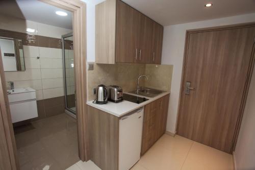a small kitchen with a sink and a shower at Bellini Hotel in Ayia Napa
