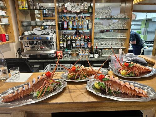 a counter with four different types of seafood on plates at Hotel Restaurant L'Europe in Saint-Florent