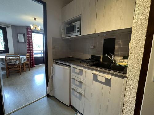une cuisine avec un évier et un plan de travail dans l'établissement Studio cosy Morillon 1100 avec balcon et casier à skis - FR-1-642-83, à Morillon