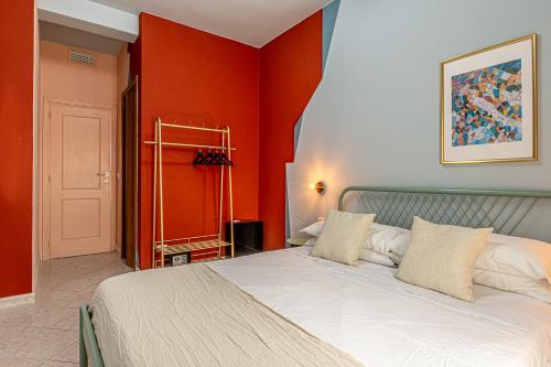 a bedroom with a large bed with orange walls at Barceloneta Experience Suite & Rooms in Alghero