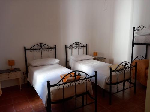 two beds in a room with white walls at Dimora Montenegro 