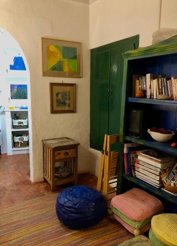 a room with a green book shelf and a table at Casa rústica com jardim privado in Tavira