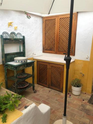 タヴィラにあるCasa rústica com jardim privadoのテーブルと傘付きの部屋