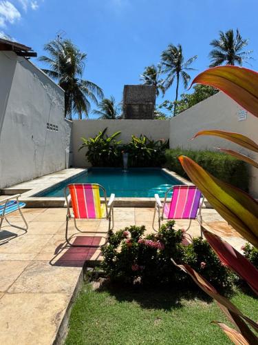 a patio with two chairs and a swimming pool at Casa Marelle in Paracuru