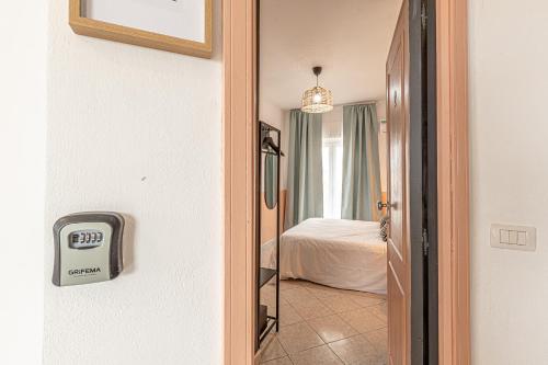 a room with a bed and a clock on the wall at Barceloneta Experience Suite & Rooms in Alghero