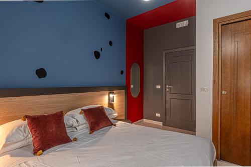 a bedroom with a bed with a blue and red wall at Barceloneta Experience Suite & Rooms in Alghero