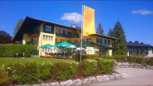 a yellow building with a flag in front of it at Hotel-Restaurant Bellevue in Ruhpolding