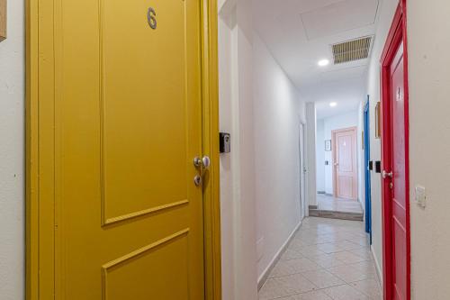 a yellow door in a room with a hallway at Barceloneta Experience Suite & Rooms in Alghero