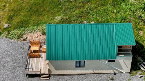 une vue aérienne d'un bâtiment avec un toit vert dans l'établissement Gudauri Private Cottage 2, à Goudaouri