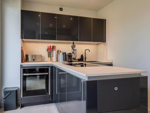 a kitchen with stainless steel appliances and black cabinets at Haus Watt`n Blick in List