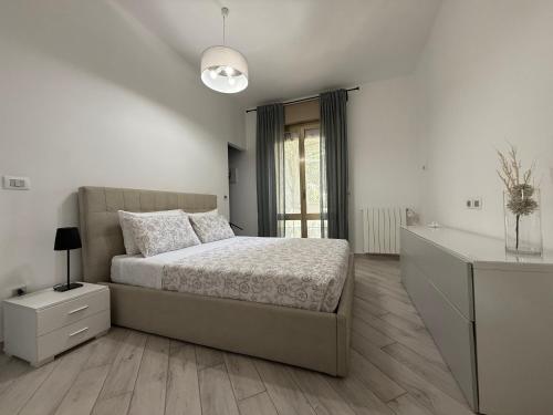 a white bedroom with a bed and a dresser at Orlandi Elegant Apartment in Bologna