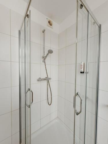 a shower with a glass enclosure in a bathroom at SAFIR by Domani Hotels in Aalst