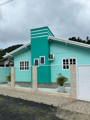 a blue house with a white at Casa Alegria com Piscina in Barracão