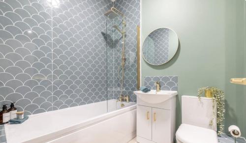 a bathroom with a tub and a toilet and a sink at Beautiful townhouse in Carrickfergus