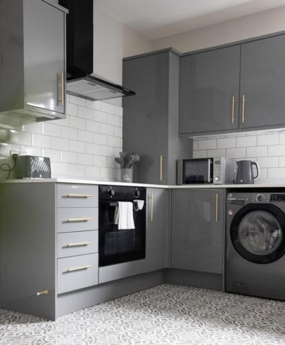 a kitchen with a washing machine and a washer at Beautiful townhouse in Carrickfergus