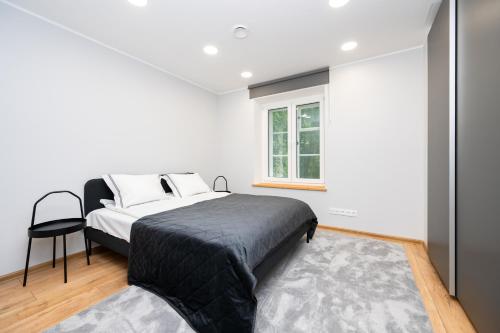 a bedroom with a bed and a window at Brand new Kalma Apartments in Tallinn