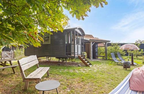 a black tiny house with chairs and a table at Tiny house, pipowagen onder de kastanje in Aalten