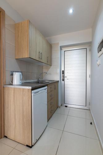 a kitchen with a sink and a dishwasher at Bellini Hotel in Ayia Napa
