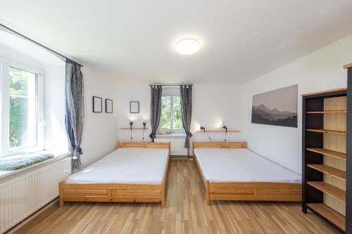 two beds in a room with two windows at Hájenka Čenkovice in Čenkovice