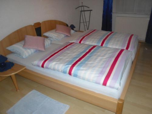 フォルバックにあるFerienwohnung Zapfの大型ベッド(赤と白のストライプシーツ、枕付)