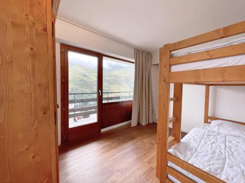 une chambre avec un lit superposé et une grande fenêtre dans l'établissement Appartement avec balcon, aux pieds des pistes, 5 pers - La Croisette, Les Ménuires - FR-1-452-250, aux Menuires