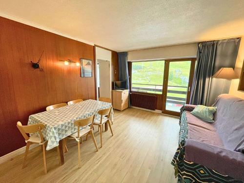une pièce avec une table, des chaises et un lit dans l'établissement Les Menuires : 2 pièces, 6 pers, balcon Sud, au pied des pistes - FR-1-452-208, aux Menuires