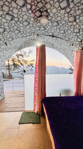 une chambre avec un lit et une vue sur l'eau dans l'établissement VSD globes days, à Kodaikānāl