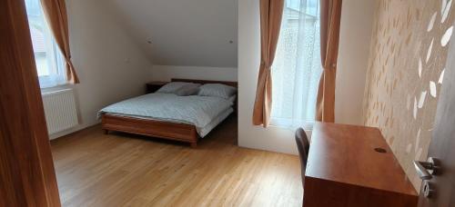 a small bedroom with a bed and a table at Apartmán v Královském Údolí in Králŭv Dvŭr