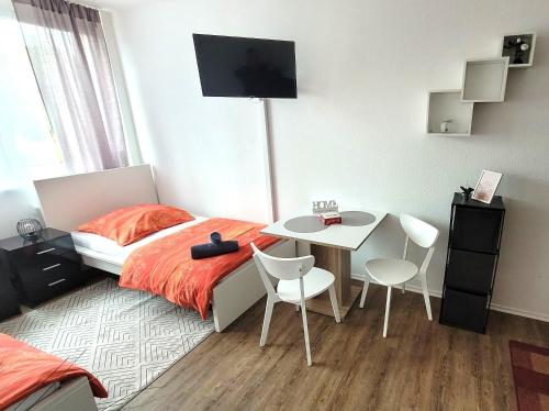 une chambre avec un lit et une table avec des chaises dans l'établissement City Appartements Mainz, à Mayence