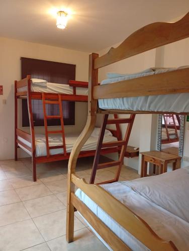 a room with three bunk beds in a house at Hostal Moai in Montañita