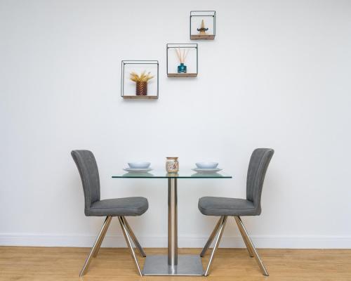 une table et deux chaises contre un mur blanc dans l'établissement Cozy Modern Apt MCR City Centre, à Manchester