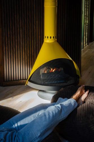 a person laying on a couch next to a fireplace at A Frame Hot Tub Couple's Getaway in Island Park