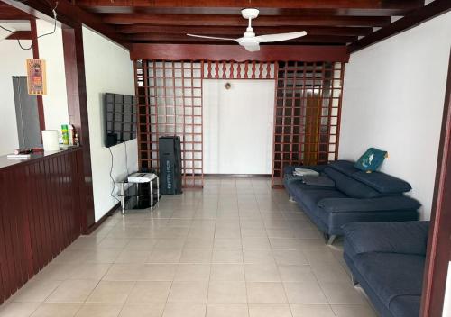 a living room with blue couches and a door at Villa Désirade in Roche Cabrit