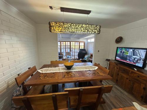 a dining room with a wooden table and a television at Casa playa moderna en las mejores playas de Chile in Bahia Inglesa