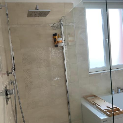 a bathroom with a shower and a toilet and a window at Affitta camere Locarno in Minusio