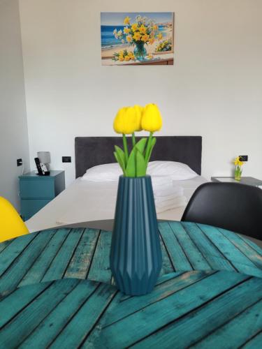 a blue vase with yellow flowers on a table at TURCOAZ Studio in Costinesti