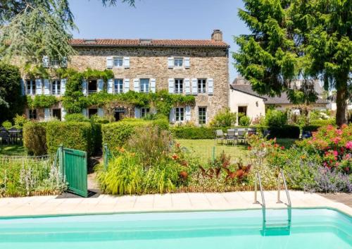 une maison avec une piscine en face d'un jardin dans l'établissement Le Manoir de Kerroc'h, à Moëlan-sur-Mer