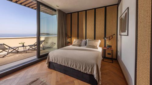 a bedroom with a large bed and a balcony at Villa Atreeum in Dubrovnik
