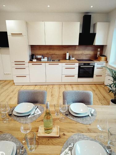 a dining room table with chairs and a kitchen at Living OH43 in Illmitz