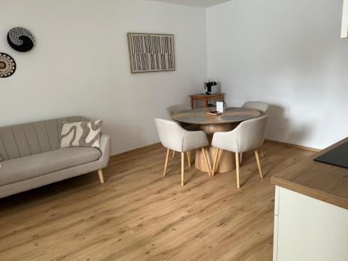 a living room with a couch and a table and chairs at Living OH43 in Illmitz