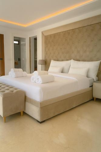 a large bedroom with a large white bed and a chair at Villa Jasmin 15 in M'diq