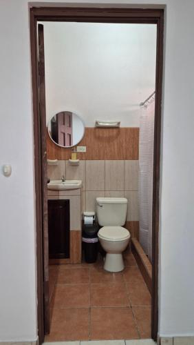 a bathroom with a toilet and a sink at Velaz Guesthouse in Alajuela City