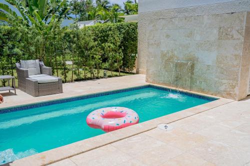 a swimming pool with a pink inflatable at Xeliter Green One Playa Dorada in San Felipe de Puerto Plata