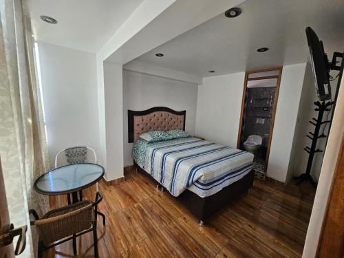 una piccola camera da letto con un letto e un tavolo di Las Margaritas Apart3 a San Sebastián