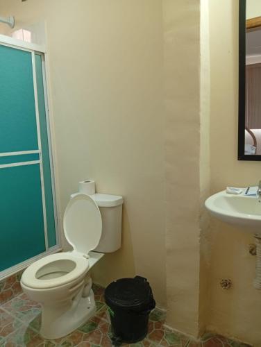 a bathroom with a toilet and a sink at Hostal Moai in Montañita