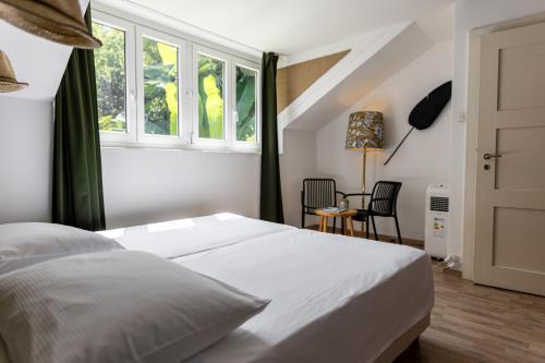 a bedroom with a white bed and a window at Easy Stay by Hotel La Perla in Ascona