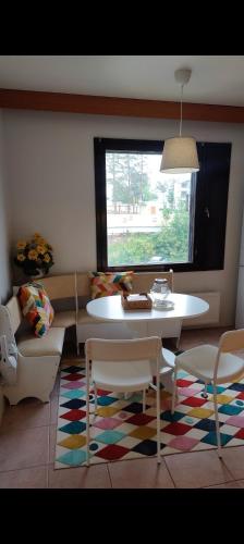 a living room with a table and chairs and a window at Spacious 3-room stay near Airport in Vantaa